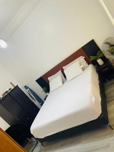 a bedroom with a large bed with white sheets and pillows at Residence Meuble Zac Mbao in Kammba
