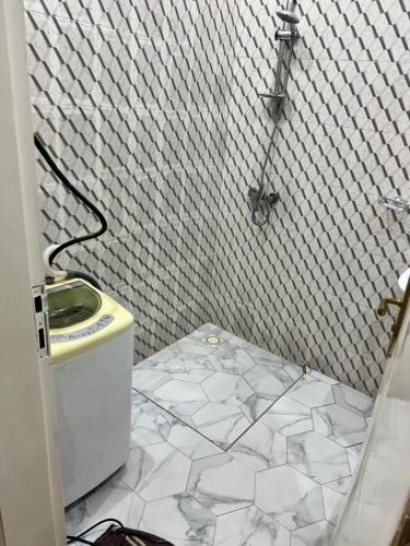 a bathroom with a sink and a white tiled floor at Residence Meuble Zac Mbao in Kammba