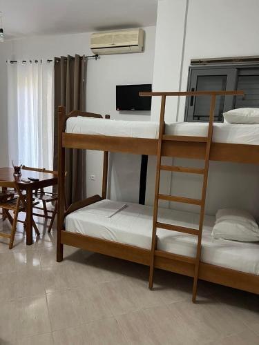 a room with three bunk beds and a table at Meta apartment in Ksamil