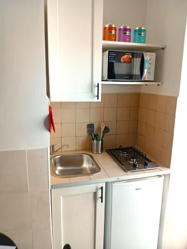 a small kitchen with a sink and a microwave at Terrazza Cristallini Napoli in Naples
