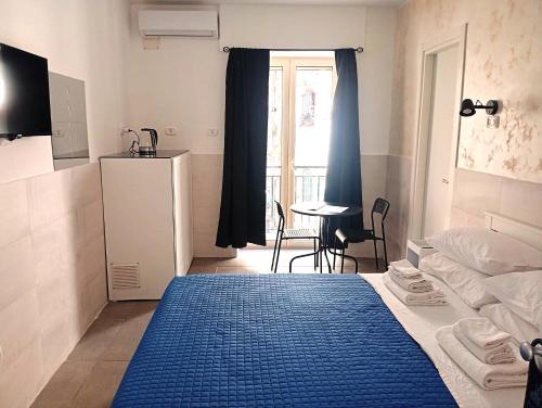 a bedroom with a bed and a table and a window at Terrazza Cristallini Napoli in Naples