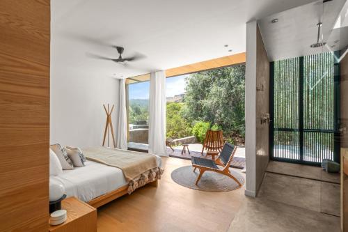 a bedroom with a bed and a large window at Hotel Cuatro Cuatros in Ensenada