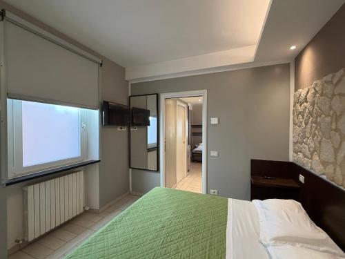 a bedroom with a green bed and a window at Al Piano 2 in Ancona