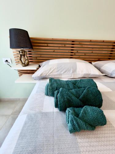 a bedroom with a bed with green towels on it at JungleHouse in Abbadia Lariana