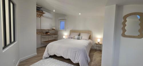 a white bedroom with a bed with white sheets at Casa Loulou in Saint-Laurent-dʼAigouze