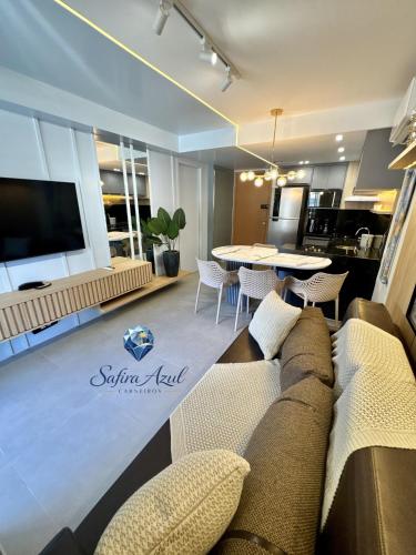 a living room with a couch and a table at Safira Azul Luxury Flat Carneiros in Tamandaré