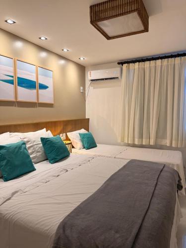a bedroom with two large beds with blue pillows at Gran Lençóis Flat Barreirinhas Caburé-209 com Quarto Deluxe Cama Queen Size in Barreirinhas