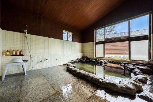 a bathroom with a large rock bathtub with animals in it at ホテル 木綿恋記 -Hotel Yufugoiki- in Yufu