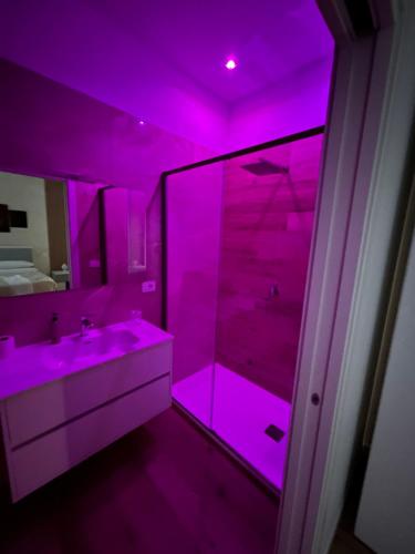a purple bathroom with a sink and a shower at Marra Home B&B in Barletta