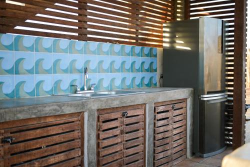a kitchen with a sink and a refrigerator at Ohana cerritos in El Pescadero