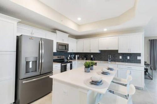 a kitchen with white cabinets and stainless steel appliances at 3 Bedrooms 2 Bathrooms Storey Lake 4751-308 CT in Orlando