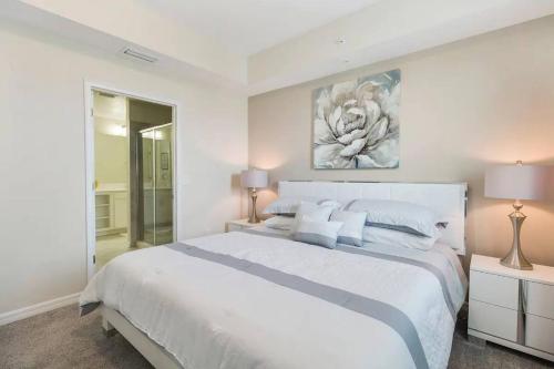 a white bedroom with a large bed and two lamps at 3 Bedrooms 2 Bathrooms Storey Lake 4751-308 CT in Orlando