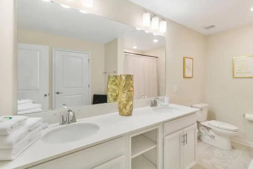 a bathroom with a sink and a toilet and a mirror at 3 Bedrooms 2 Bathrooms Storey Lake 4751-308 CT in Orlando