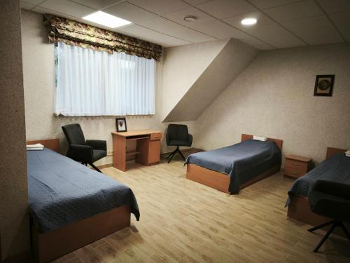 a hotel room with two beds and a desk at Pilnų namų bendruomenė in Panara