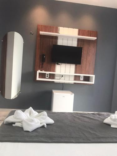 a bedroom with a bed with a tv and a mirror at Pousada WL Império in Canoa Quebrada