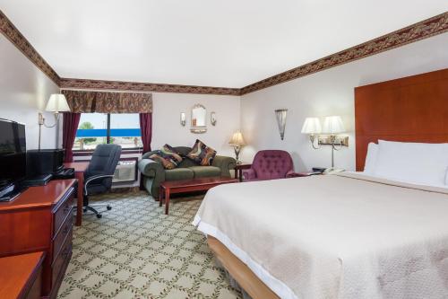 a hotel room with a bed and a television at Days Inn by Wyndham Dyersburg in Dyersburg