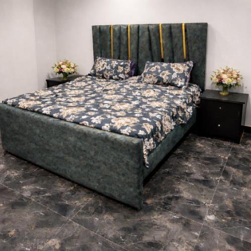 a large bed in a room with two night stands at Dawood Apartments Bahria Town Lahore in Lahore