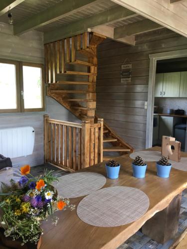 a dining room with a wooden table with flowers on it at Le chalet des Cambuses in Saint Die