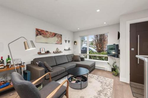a living room with a couch and a table at Elite Townhouse at the Shipyaards in North Vancouver