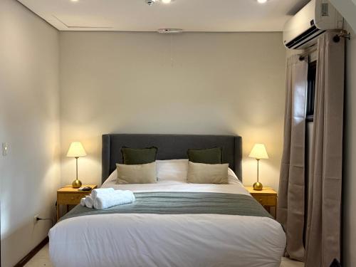a bedroom with a large bed with two lamps at Casa KOMU in Asunción