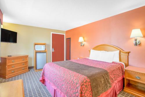 a hotel room with a bed and a tv at Days Inn by Wyndham Elko in Elko