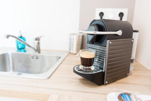 eine Tasse Kaffee in einem Toaster auf der Theke in der Unterkunft Au Coeur de Nantes Apartment in Nantes