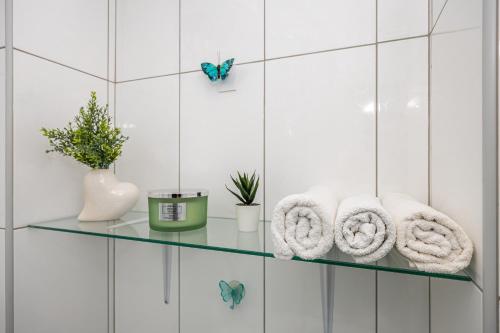 a glass shelf with towels and a butterfly in a bathroom at Casa Vita in Dramalj