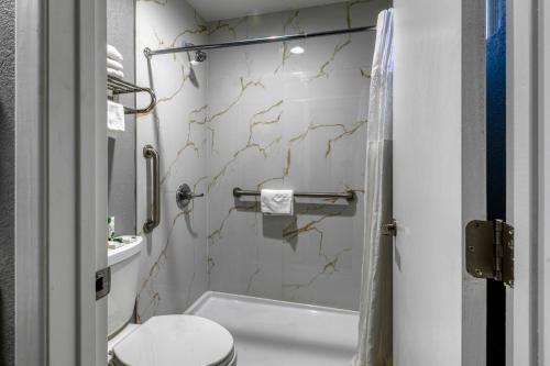 a small bathroom with a toilet and a sink at Copper Manor Motel in Silver City
