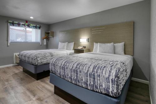 a hotel room with two beds and a window at Copper Manor Motel in Silver City
