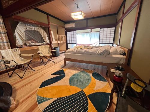 a bedroom with a bed and a rug on the floor at HAPPY MAGIC guesthouse in Tateyama