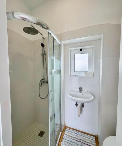 a bathroom with a sink and a shower at Yellow Guesthouse in Faro