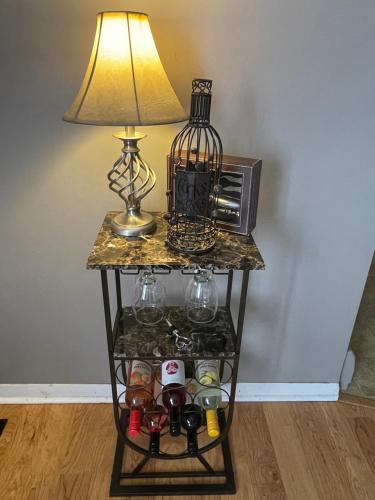 a side table with a lamp and a microwave at Private king suite in Dubuque