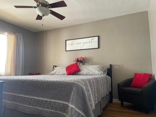 a bedroom with a bed with a ceiling fan and a chair at Private king suite in Dubuque