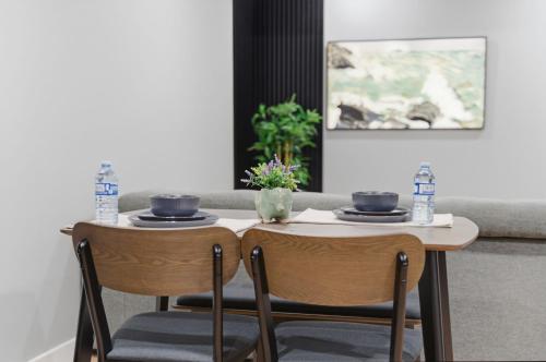 a table and two chairs with plates and water bottles at Mountain Escape Deluxe King Suite-Free Parking in Cochrane