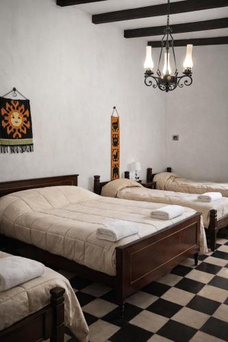 a room with three beds and a chandelier at Inti Raymi in Maimará