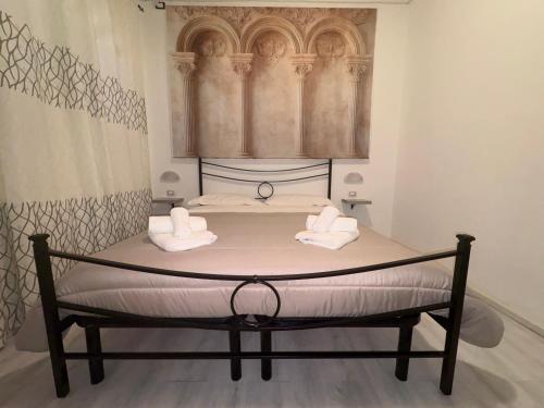 a bed in a room with two towels on it at Il piccolo tempio di Ely in Termoli