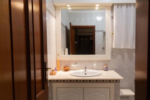 a bathroom with a sink and a mirror at Casa da Lala - Alojamento a 4km de Fátima in Fontainhas