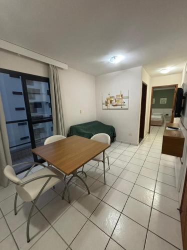 a dining room with a table and chairs in a room at Flats Beira Mar in Caraguatatuba