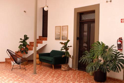 a living room with a green chair and potted plants at Casa Sabina Expiatorio in Guadalajara