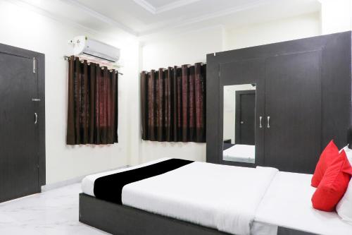 a bedroom with a bed with black doors and red pillows at Hotel O Figtree Premier in Patna