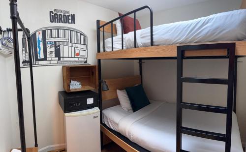 a dorm room with two bunk beds and a desk at Chelsea Rooms NYC in New York