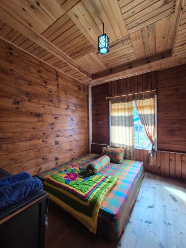 a bedroom with a large bed in a wooden room at Serenity homestay in Mamasa