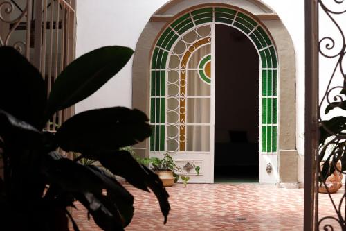 a door with a green window and a plant at Casa Sabina Expiatorio in Guadalajara