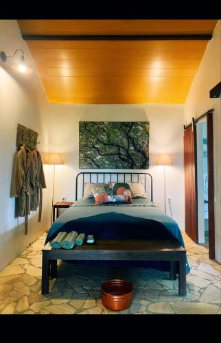 a bedroom with a bed and a painting on the wall at Chalé da árvore Buzios in Búzios