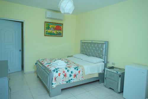 a bedroom with a bed with a floral bedspread at Hotel Anedi in Concepción de La Vega