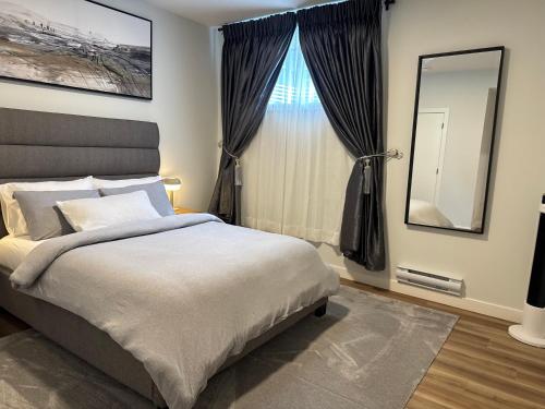 a bedroom with a bed and a large window at 5 Star Suite with Free Parking and Easy Access to Downtown in Calgary