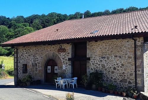 a building with a table and chairs in front of it at Hermoso Caserío Navarra. (Madoz) in Madoz