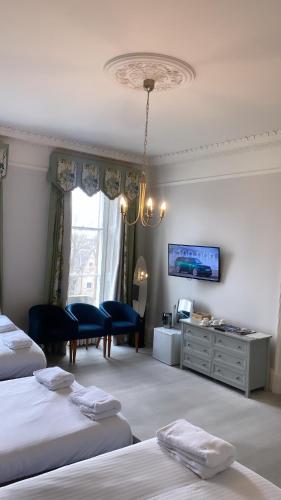 a hotel room with two beds and a tv at West Coates Mansion in Edinburgh