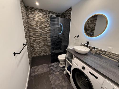 a bathroom with a sink and a washing machine at Cosy home in Saint Martin