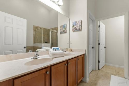 a bathroom with a sink and a large mirror at 5 Bedrooms 3 Bathrooms Veranda Palms 4458 NP in Orlando